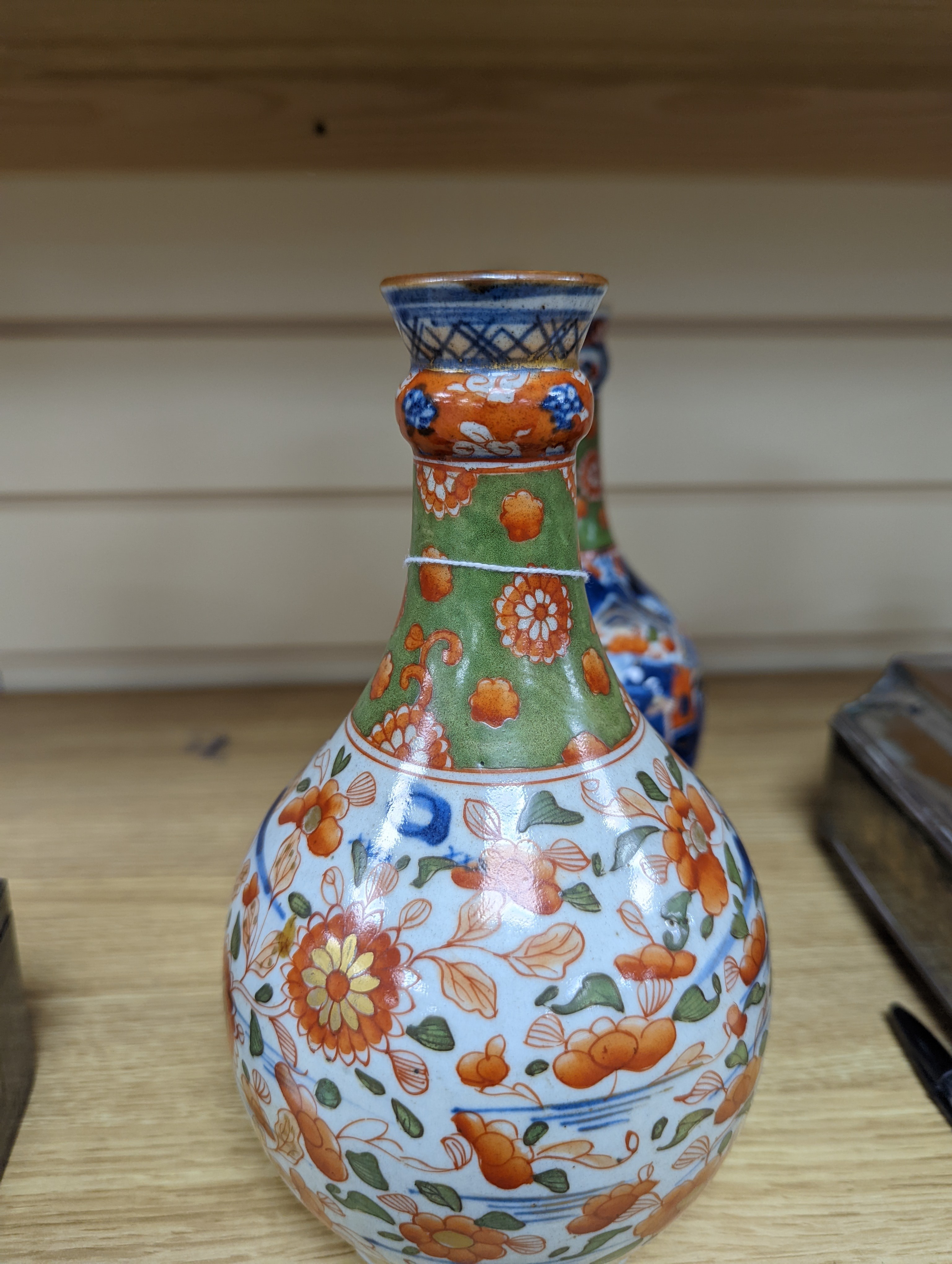 A pair of 18th century Chinese clobbered blue and white bottle vases 23cm